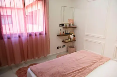 a bedroom with a bed with a pink blanket and a window at Luxurious apartment in Marrakech