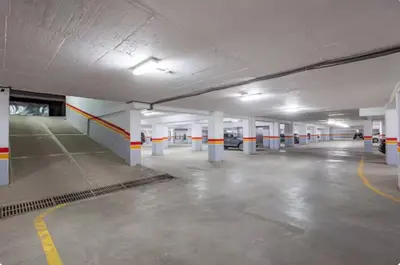 an empty parking garage with white and orange columns at Premium studio - Hivernage Marrakech in Marrakech