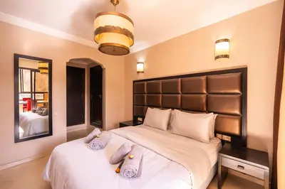 a bedroom with a large bed with two pillows on it at River Palm élégant appartement 2 ch vue piscine in Marrakech