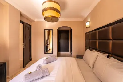 a bedroom with a large white bed with towels on it at River Palm élégant appartement 2 ch vue piscine in Marrakech