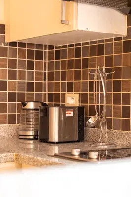 a kitchen counter top with a microwave and a stove at River Palm élégant appartement 2 ch vue piscine in Marrakech