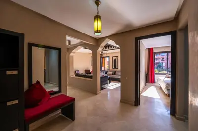 a living room with a red chair in a room at River Palm élégant appartement 2 ch vue piscine in Marrakech