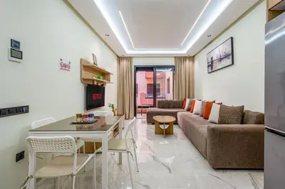 a living room with a couch and a table at Stylish Flat, Aube hivernage Fibre-Pool & Parking in Oulad Akkou