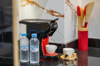 a toaster and two bottles of water on a counter at Stylish Flat, Aube hivernage Fibre-Pool & Parking in Oulad Akkou