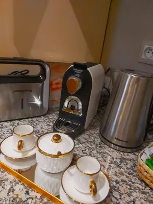 a kitchen counter with a toaster and three tea cups at High Standing Duplex & Pool 10 min Center in Marrakech
