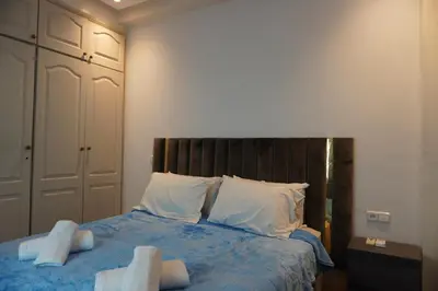 a bedroom with a bed with blue sheets and white pillows at Comfort Appartment Centre Marrakech in Marrakech