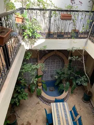 a balcony with a table and chairs and plants at Riad Zinnha 2 in Marrakech