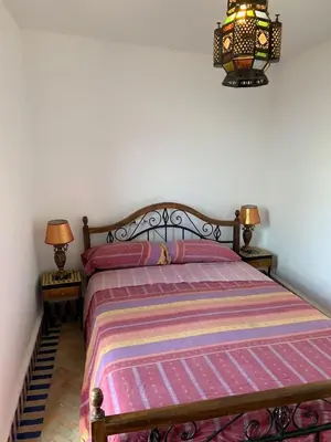 a bed in a bedroom with two lamps and a bedspread at Riad Zinnha 2 in Marrakech
