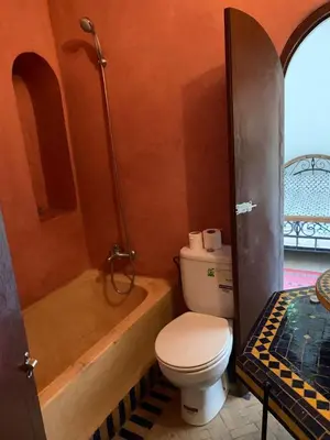 a bathroom with a toilet and a bath tub at Riad Zinnha 2 in Marrakech