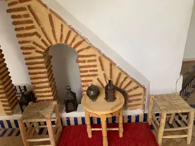 a room with a staircase with a table and chairs at Riad Zinnha 2 in Marrakech