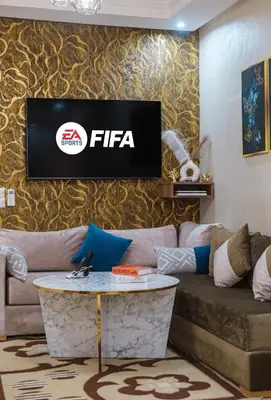 a living room with a couch and a tv on a wall at Marrakech Chic apartment in Marrakech
