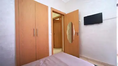 a bedroom with a bed and a flat screen tv at Marrakech Chic apartment in Marrakech