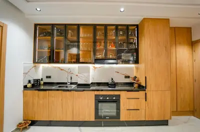 a kitchen with wooden cabinets and a stove at Magnifique Appartement Hivernage in Marrakech