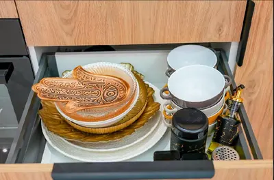 a drawer filled with plates and bowls in a cabinet at Magnifique Appartement Hivernage in Marrakech