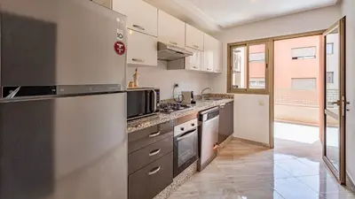 a kitchen with stainless steel appliances and a large window at Appartement moderne 5 min au centre ville in Marrakech