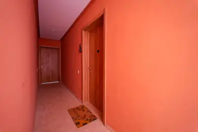an empty hallway with an orange wall and a door at Appartement Domaine de Nouria in Marrakech