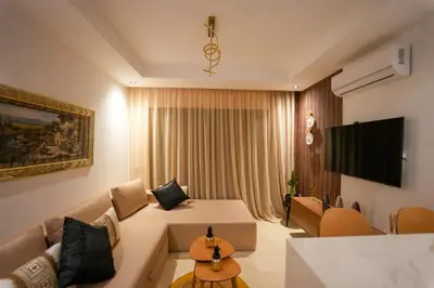 a living room with a couch and a tv at Appartement Domaine de Nouria in Marrakech