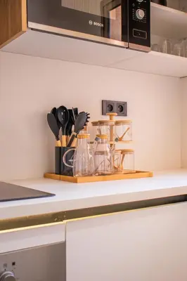 a kitchen counter with a shelf with utensils at Appartement avec GOLF PISCINE Prestigia Jade in Marrakech