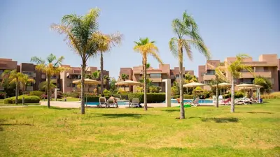 a park with palm trees and a resort at Appartement avec GOLF PISCINE Prestigia Jade in Marrakech