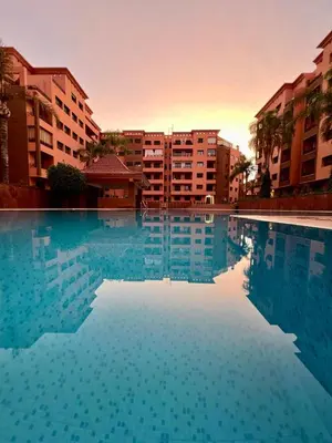 a large pool of water with buildings in the background at Bel appartement à Babylone 1 in Marrakech