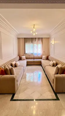 a living room with two couches and a table at Bel appartement à Babylone 1 in Marrakech