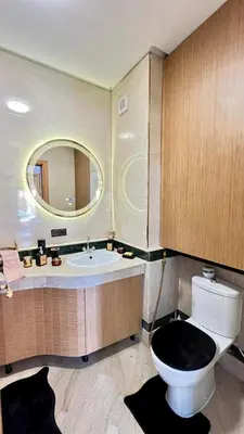 a bathroom with a toilet and a sink and a mirror at Bel appartement à Babylone 1 in Marrakech