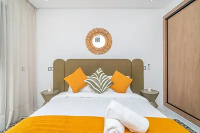 a bedroom with a bed with yellow and orange pillows at Urban Escape in Gueliz with Balcony and Wifi in Marrakech