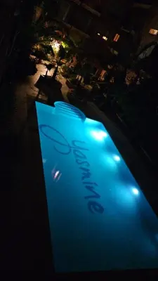 a sign in the middle of a pool of water at night at Yasmine Majorelle Residence Apartment in Marrakech