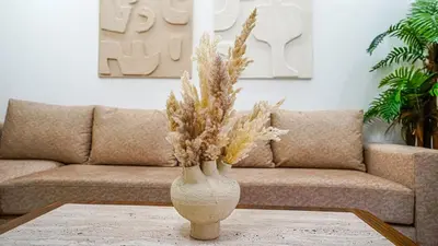 a vase with flowers on a table in front of a couch at Yasmine Majorelle Residence Apartment in Marrakech