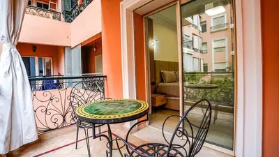 a patio with a table and chairs on a balcony at Yasmine Majorelle Residence Apartment in Marrakech
