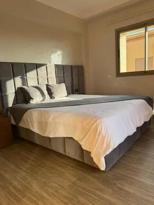 a large bed in a bedroom with a window at Appartement de luxe avec piscine et parking gratuit in Marrakech