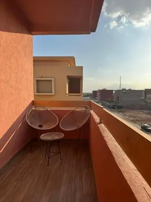 two chairs on a balcony with a view of a city at Appartement de luxe avec piscine et parking gratuit in Marrakech