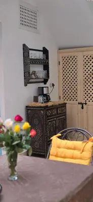 a dining room table with a vase of flowers on a table at Riad Kasbah 82 in Marrakech