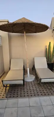 two beds sitting under an umbrella on a patio at Riad Kasbah 82 in Marrakech
