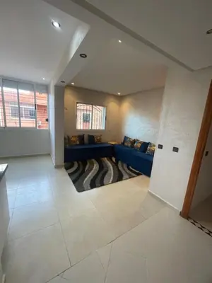 a living room with a blue couch and a window at Résidence Al Aziziya Near Marrakech Airport in Marrakech