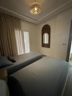 a bedroom with a bed and a chandelier at Le style a marrakech in Marrakech