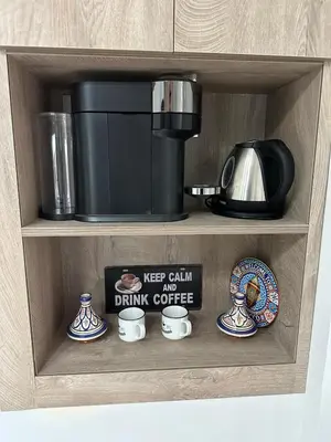 a shelf with a coffee maker and cups on it at Le style a marrakech in Marrakech