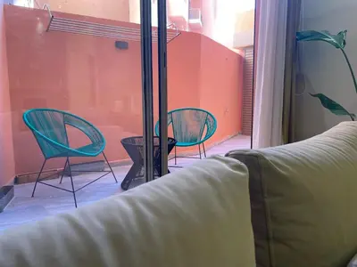 a living room with two chairs and a window at Majorelle Apartment YSL in Marrakech