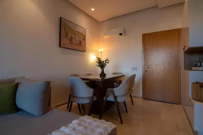 a living room with a dining room table and chairs at Premium Apartment in Marrakech Argan Golf Residence with pool & WiFi in Marrakech