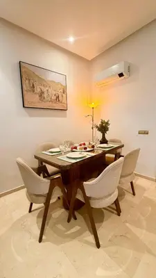 a dining room with a wooden table and chairs at Premium Apartment in Marrakech Argan Golf Residence with pool & WiFi in Marrakech
