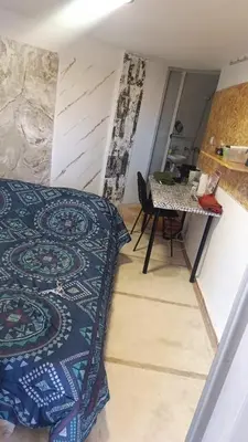 a bedroom with a bed and a table in a room at Chambre individuelle studio in Marrakech