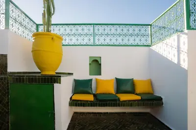 a bench with yellow and green pillows and a vase at La Douiria Zaouia in Marrakech