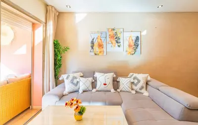 a living room with a couch and a table at Stylish Flat, Pool, Garden & Fast Wi-Fi in Marrakech
