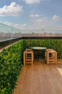 a patio with a table and two stools on a roof at The Blue Harmony - Hivernage Marrakech in Marrakech