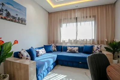 a blue couch in a living room with a window at The Blue Harmony - Hivernage Marrakech in Marrakech