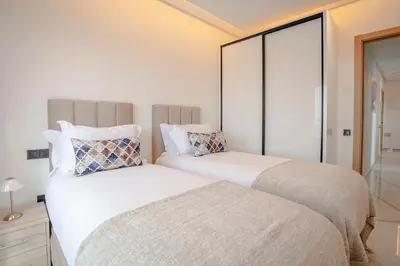 two beds sitting next to each other in a bedroom at The Blue Harmony - Hivernage Marrakech in Marrakech