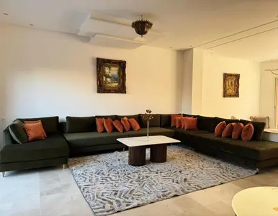 a living room with a green couch and a table at Friendly family home in a peaceful location in Marrakech
