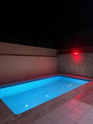 a swimming pool at night with a red light at Friendly family home in a peaceful location in Marrakech