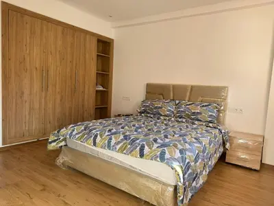 a bedroom with a bed and a wooden cabinet at Friendly family home in a peaceful location in Marrakech