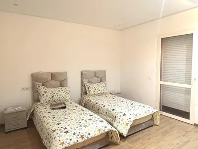 a bedroom with two beds and a window at Friendly family home in a peaceful location in Marrakech
